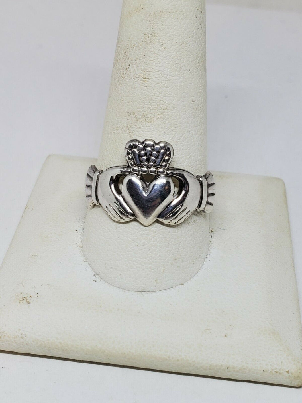 two hands holding a heart ring
